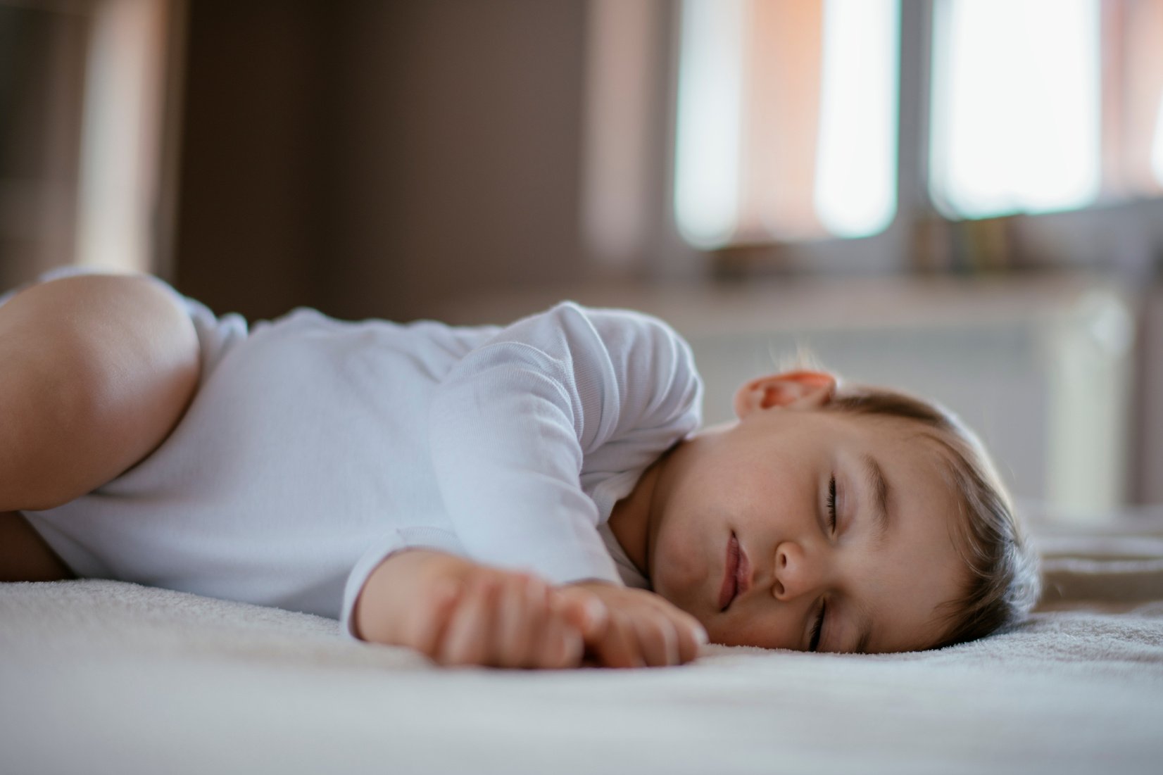 a baby sleeping on a mattress in a room